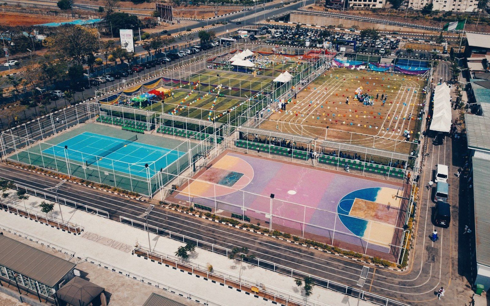 Aerial view of a multi-sport complex with tennis courts, basketball court and turf fields