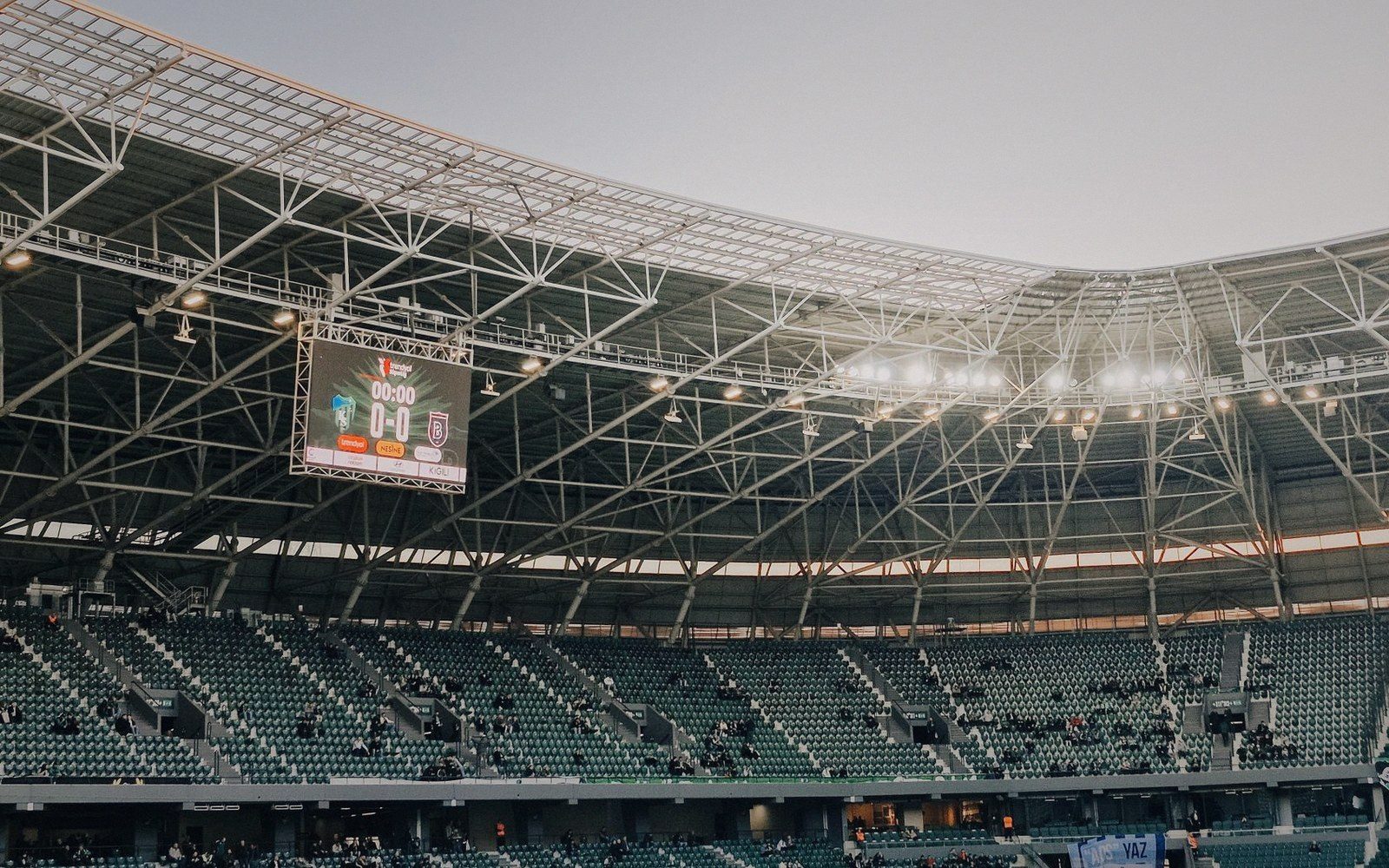 Large electronic scoreboard facing empty stands, screen black and powered off, venue quiet